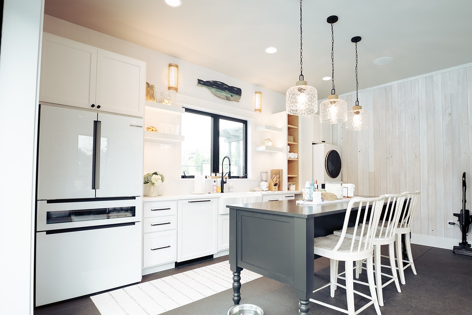 The pool house kitchen with glass pendants and a farmhouse sink