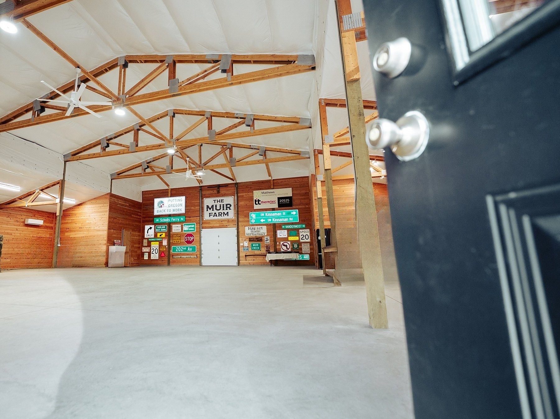 Through the barn door to the open interior with exposed wood trusses