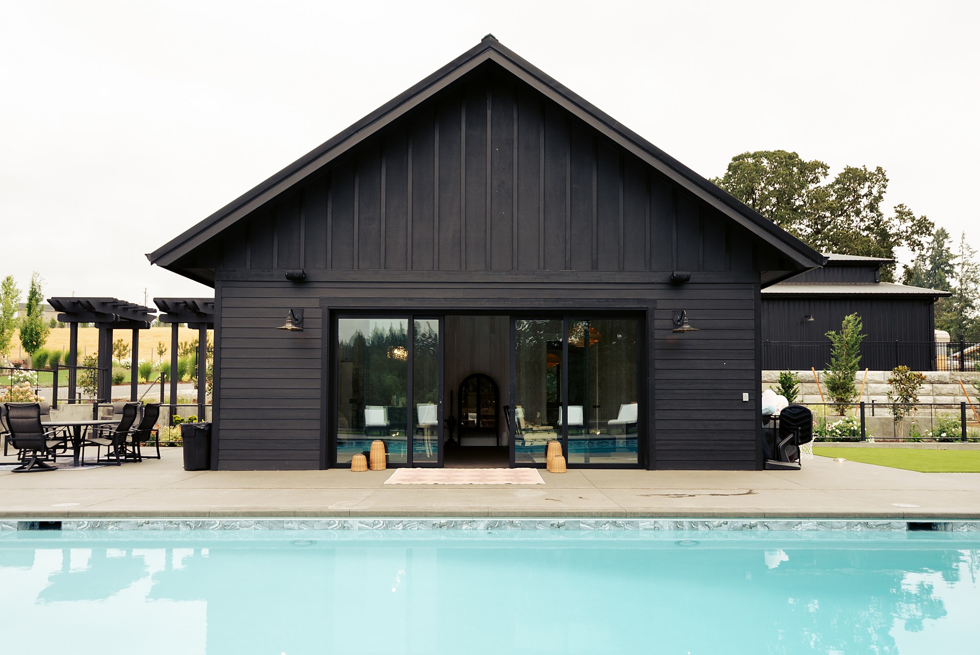 The black pool house across the pool