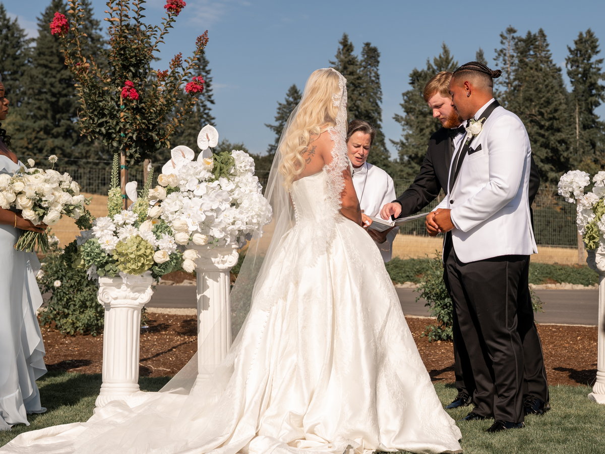 The exchange of rings during a ceremony on the lawn