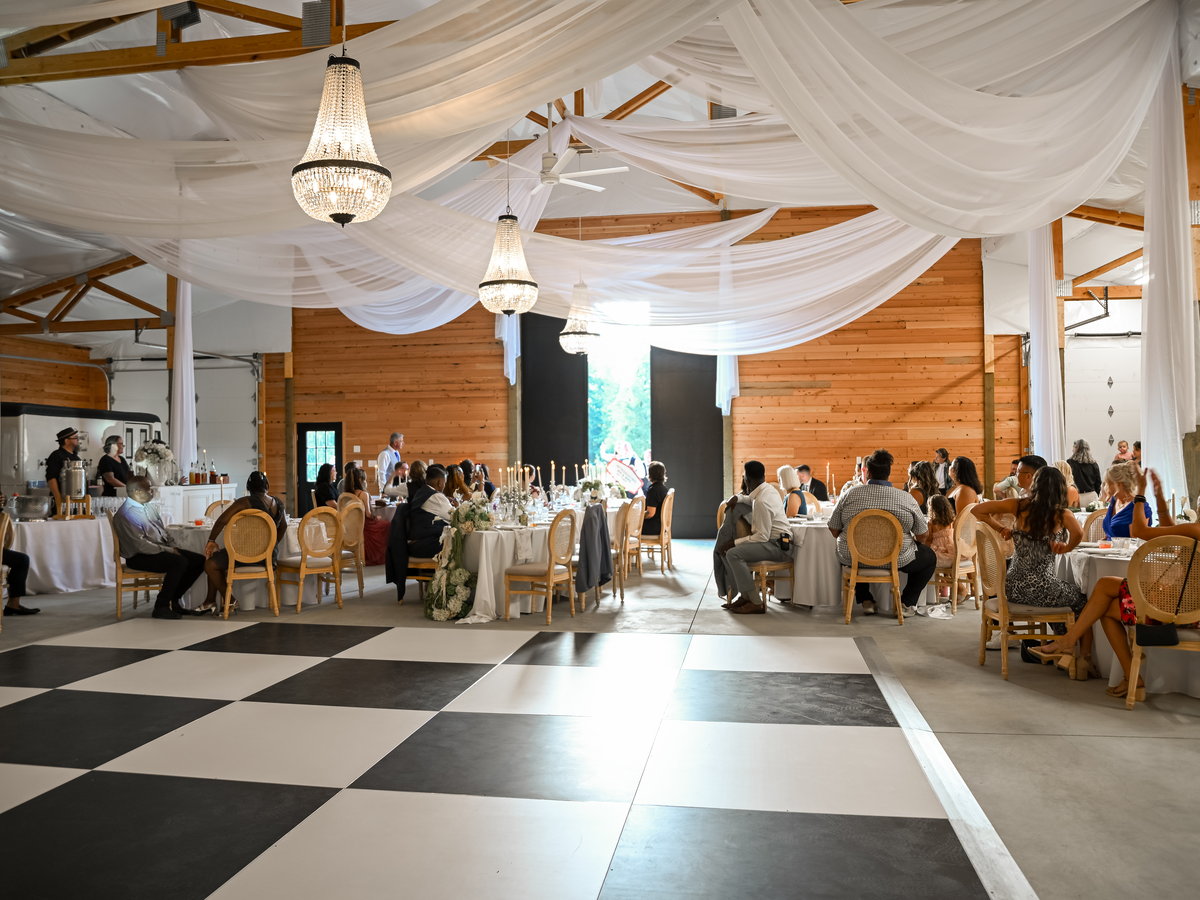 The barn set for dinner, with draped ceiling and chequered dance floor