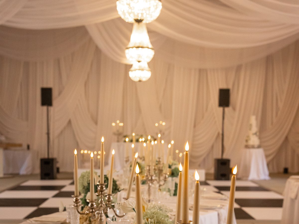 A candlelit dinner table beneath the chandeliers